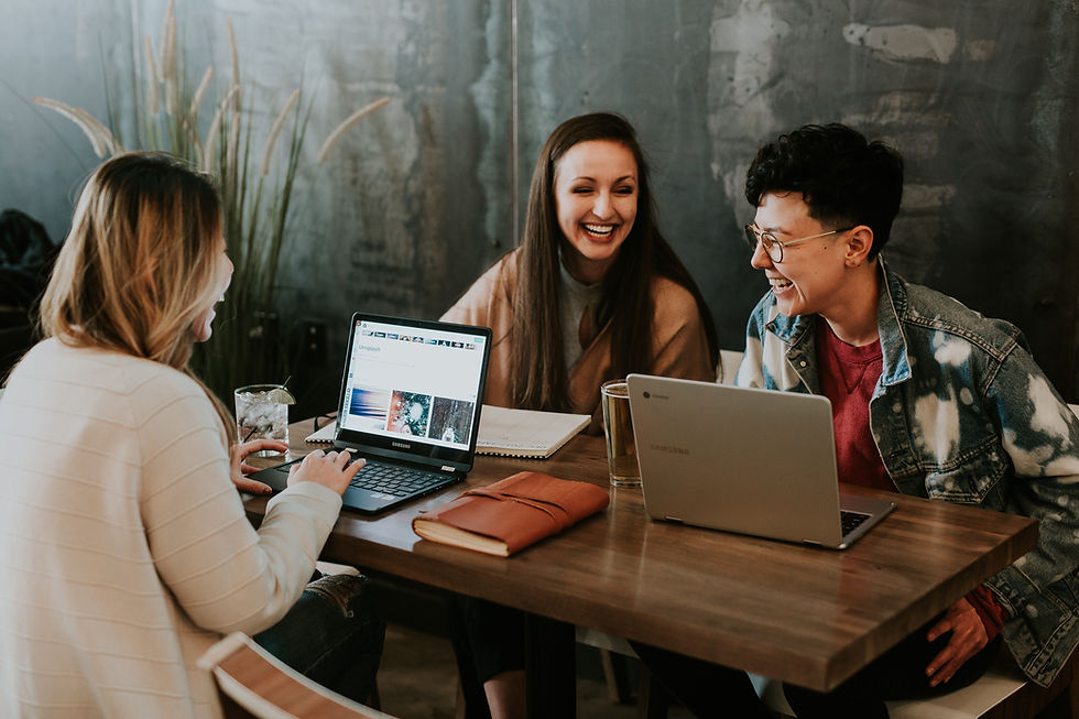 co-workers sitting at desk laughing
